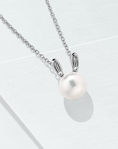 Birks Essentials pearl and silver rabbit necklace on a light blue background